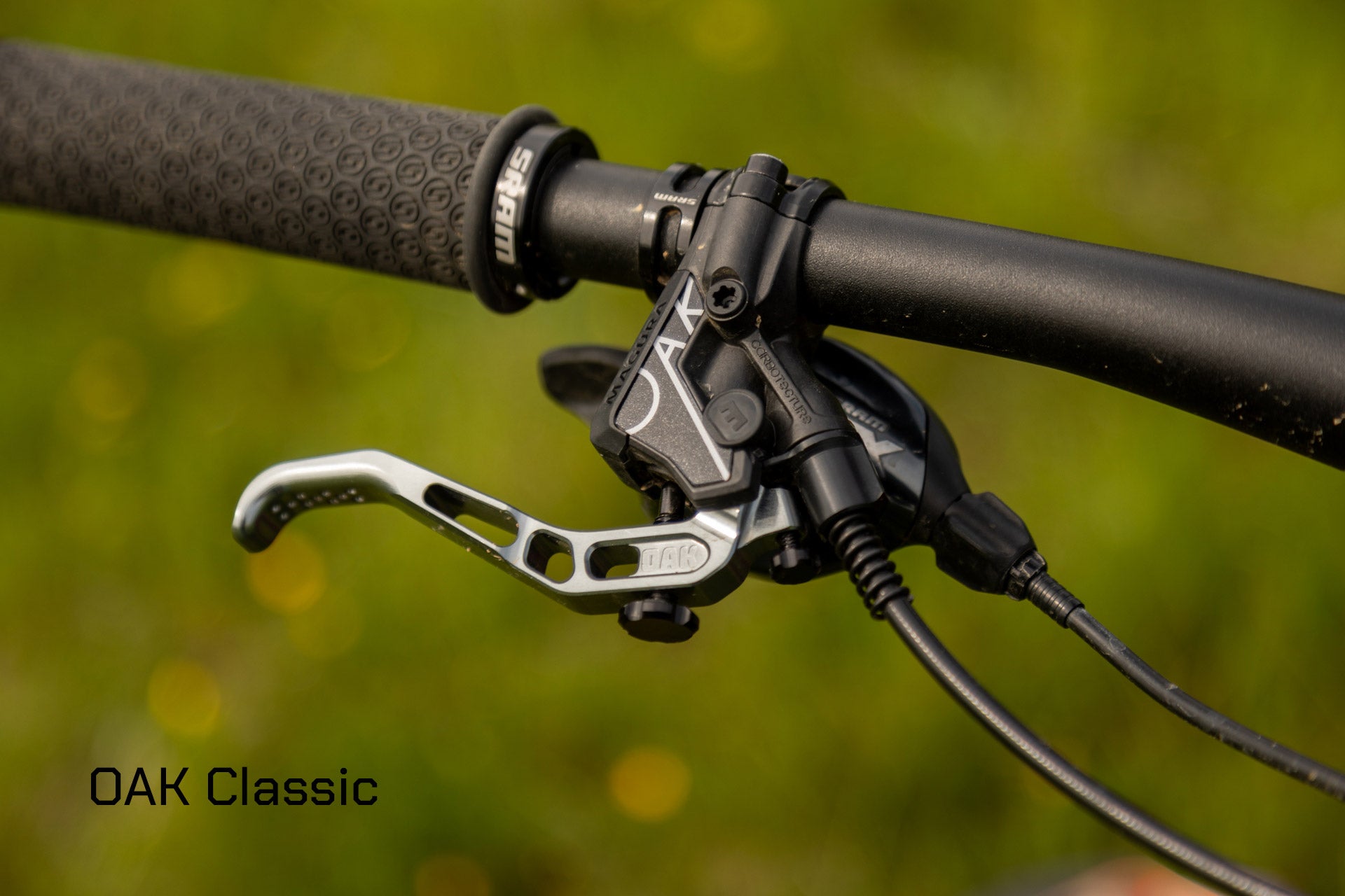Matte black mountain bike handlebar with textured grip and silver engraved brake lever connected to SRAM assembly