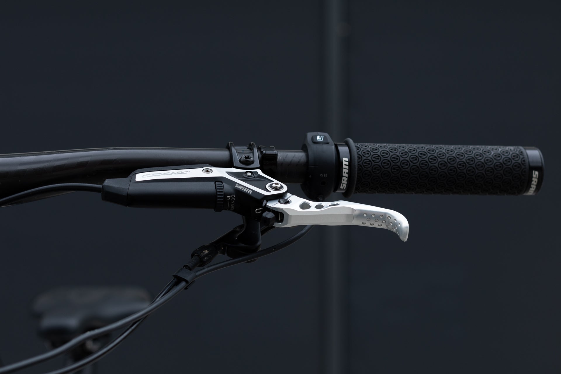 Close-up of a mountain bike's left handlebar with SRAM gear shifter and number 3 indicator.