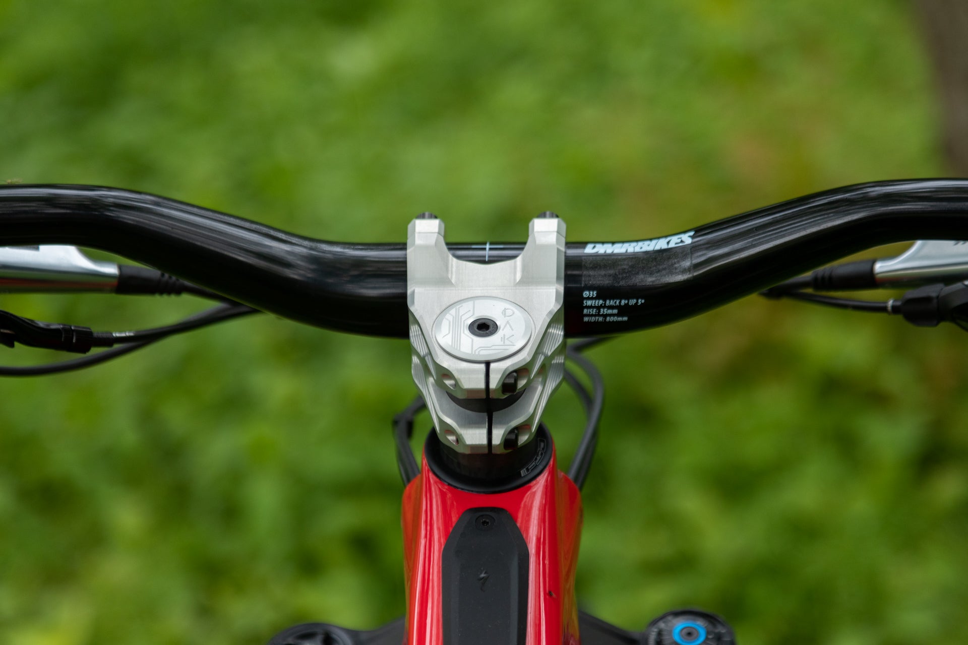 Black DMRBIKES mountain bike handlebars with 35mm rise, 800mm width, on a silver stem and red frame