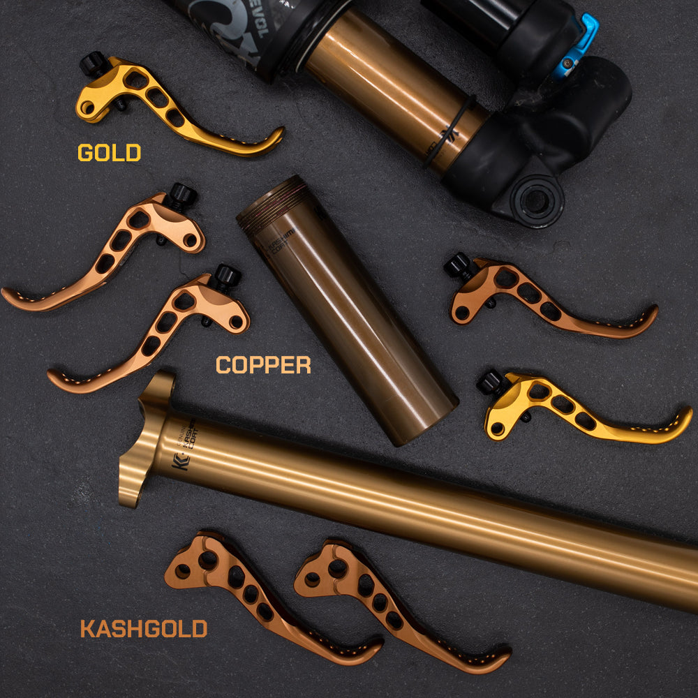 Metallic gold and copper bike levers with black EVOL suspension featuring a blue adjustment knob.