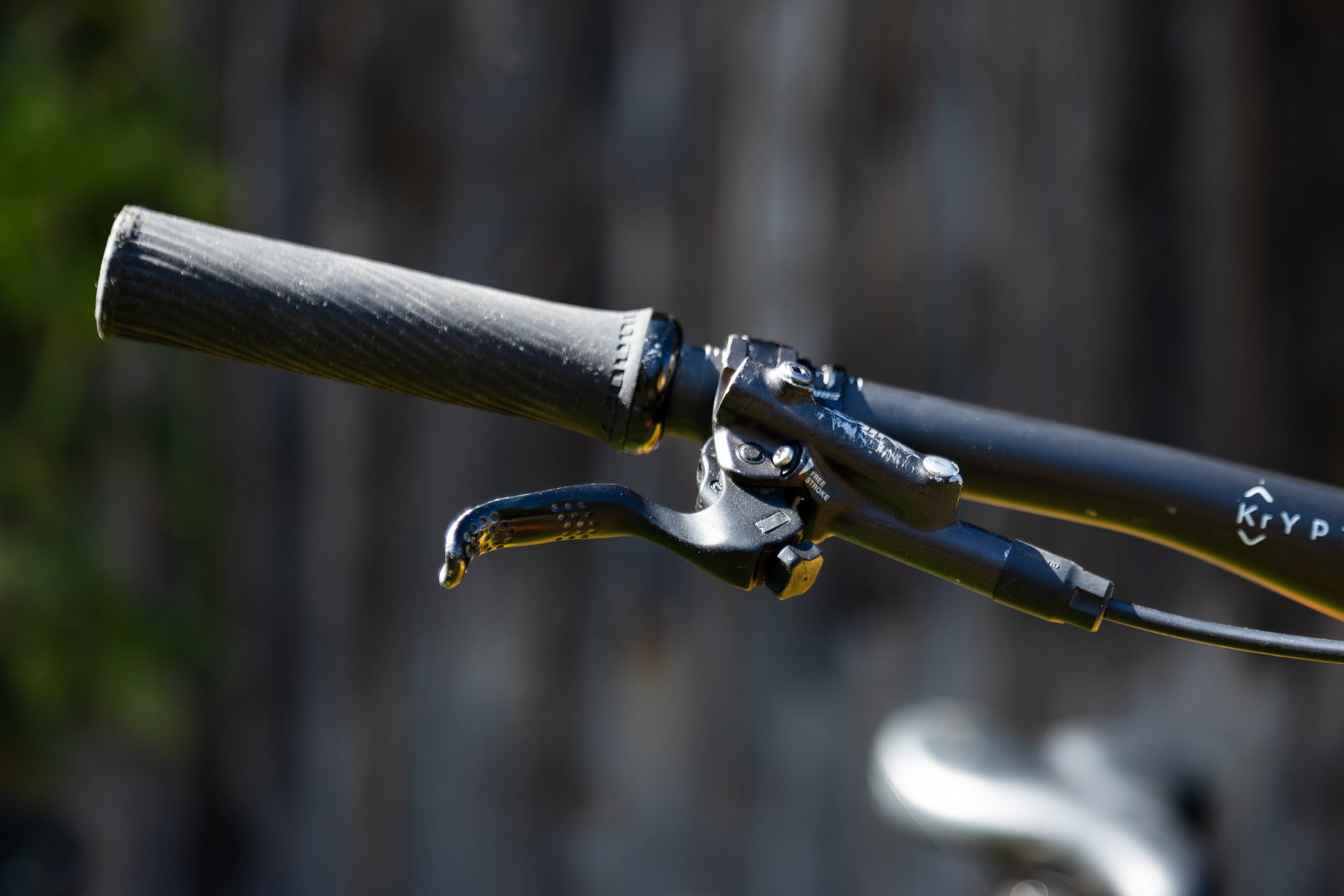 Close-up of black mountain bike handlebar with ergonomic STROKE hydraulic brake lever and grip