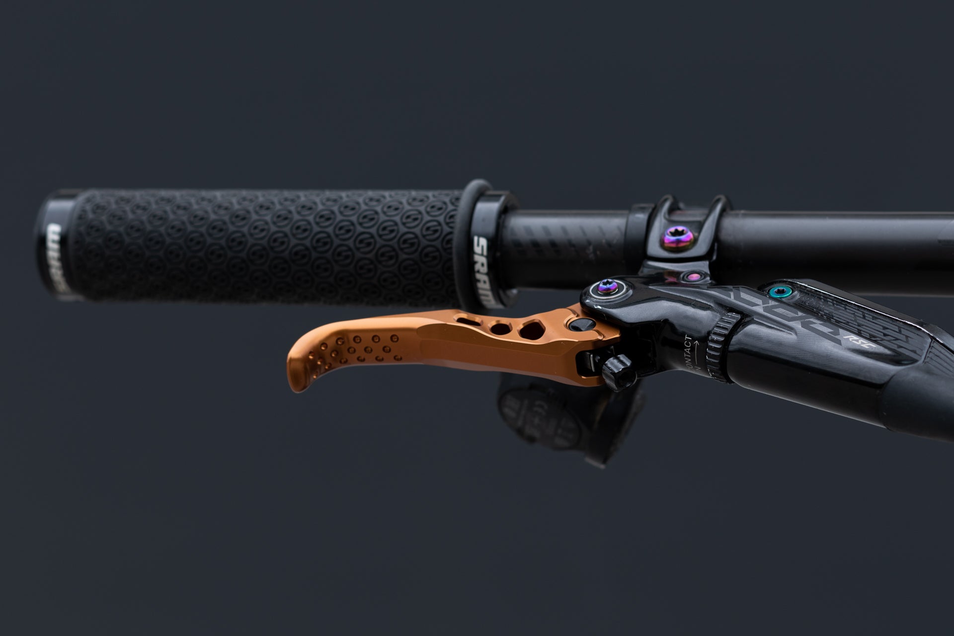 Close-up of black textured SRAM bicycle handlebar grip with orange brake lever and ONTACT logo.