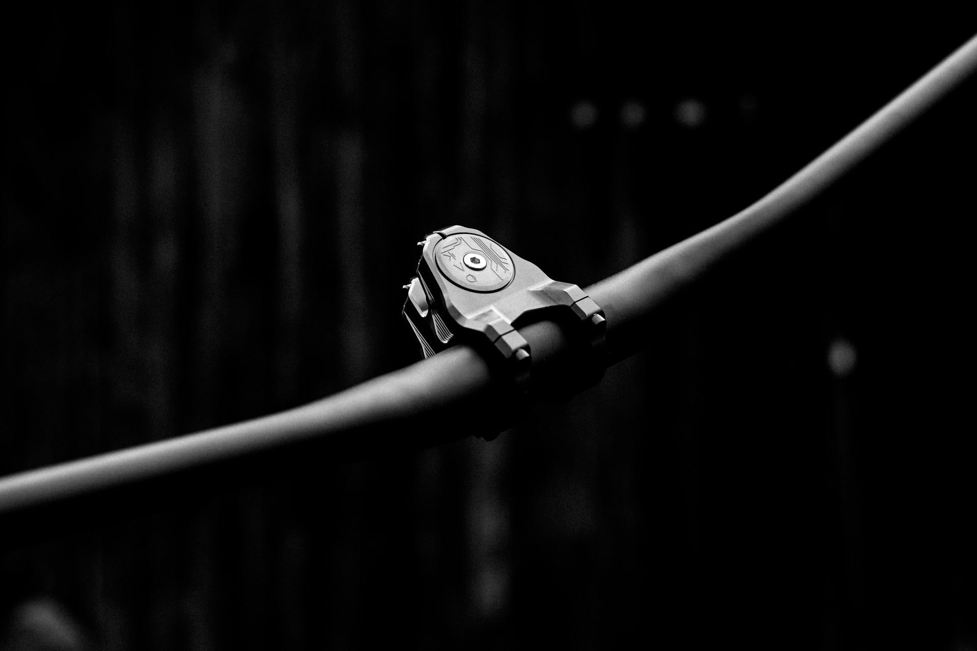 Modern mountain bike handlebar with electronic bike computer in high contrast lighting