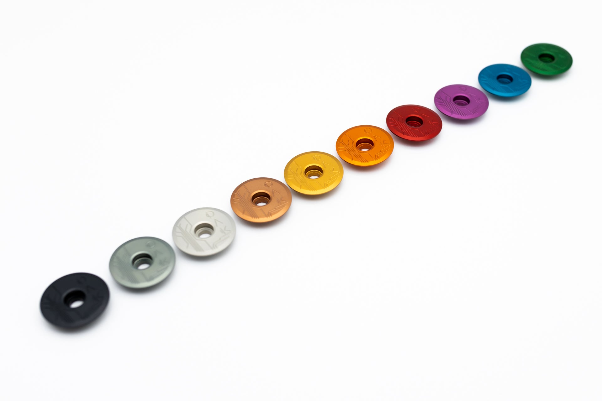 Ten colorful round discs with central holes and engravings, representing mountain biking parts.