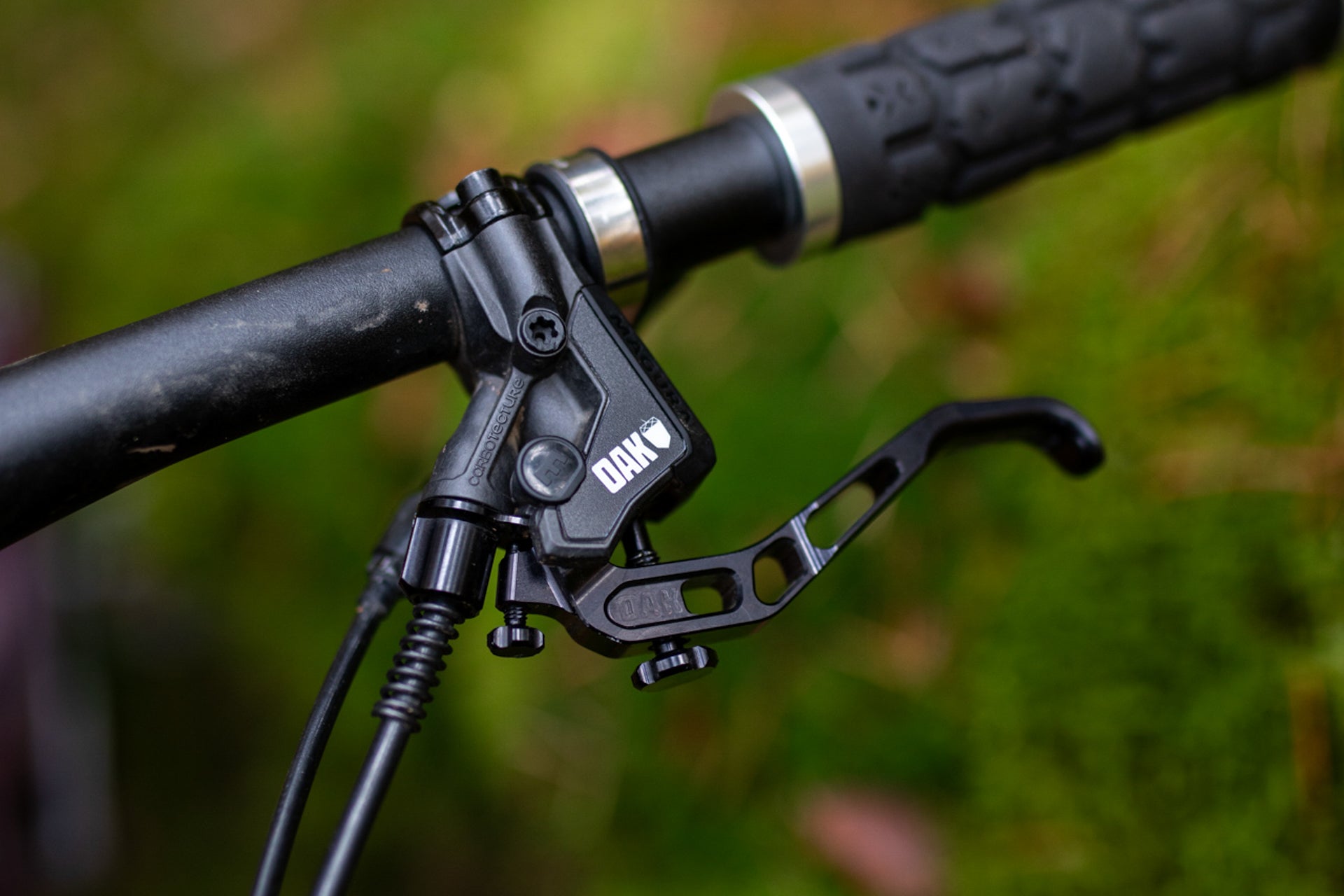 Close-up of OAK branded black bicycle brake lever with ergonomic design on handlebar