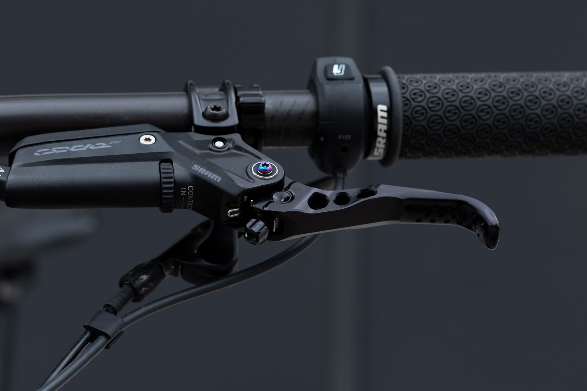 Close-up of black SRAM bicycle brake lever assembly and textured handlebar grip.